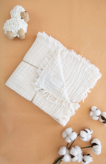 100% muslin baby blanket with four layers, measuring 110x120 cm, available in multiple colors including white, pink, beige, red, purple, yellow, and blue. The blanket features a soft, breathable texture for extra comfort, perfect for babies and toddlers. Ideal for use as a swaddle, stroller cover, or lightweight bedding. Showcased in elegant folded styles with cotton accents, emphasizing its premium quality and durability.