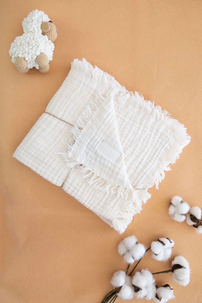 100% muslin baby blanket with four layers, measuring 110x120 cm, available in multiple colors including white, pink, beige, red, purple, yellow, and blue. The blanket features a soft, breathable texture for extra comfort, perfect for babies and toddlers. Ideal for use as a swaddle, stroller cover, or lightweight bedding. Showcased in elegant folded styles with cotton accents, emphasizing its premium quality and durability.