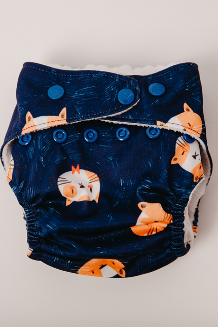 Eco-friendly cloth diaper with a fox print on navy blue fabric. adjustable snaps for a perfect fit and soft, breathable material that’s gentle on baby skin. Reusable and washable, designed for day & night use. parents seeking sustainable diapers.