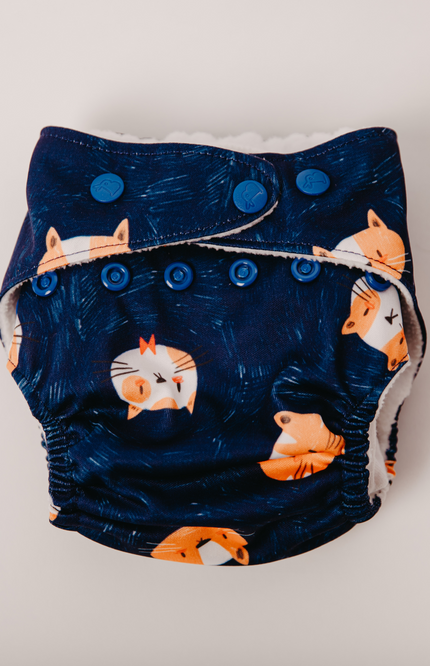 Eco-friendly cloth diaper with a fox print on navy blue fabric. adjustable snaps for a perfect fit and soft, breathable material that’s gentle on baby skin. Reusable and washable, designed for day & night use. parents seeking sustainable diapers.