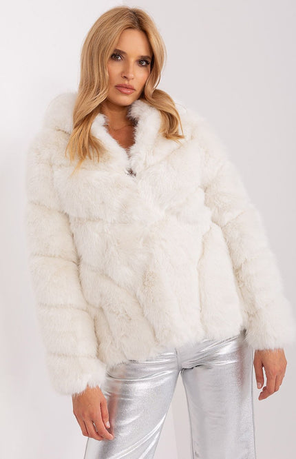 White faux fur jacket with hood, styled with metallic silver pants.