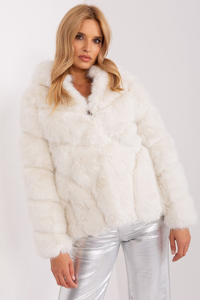 White faux fur jacket with hood, styled with metallic silver pants.